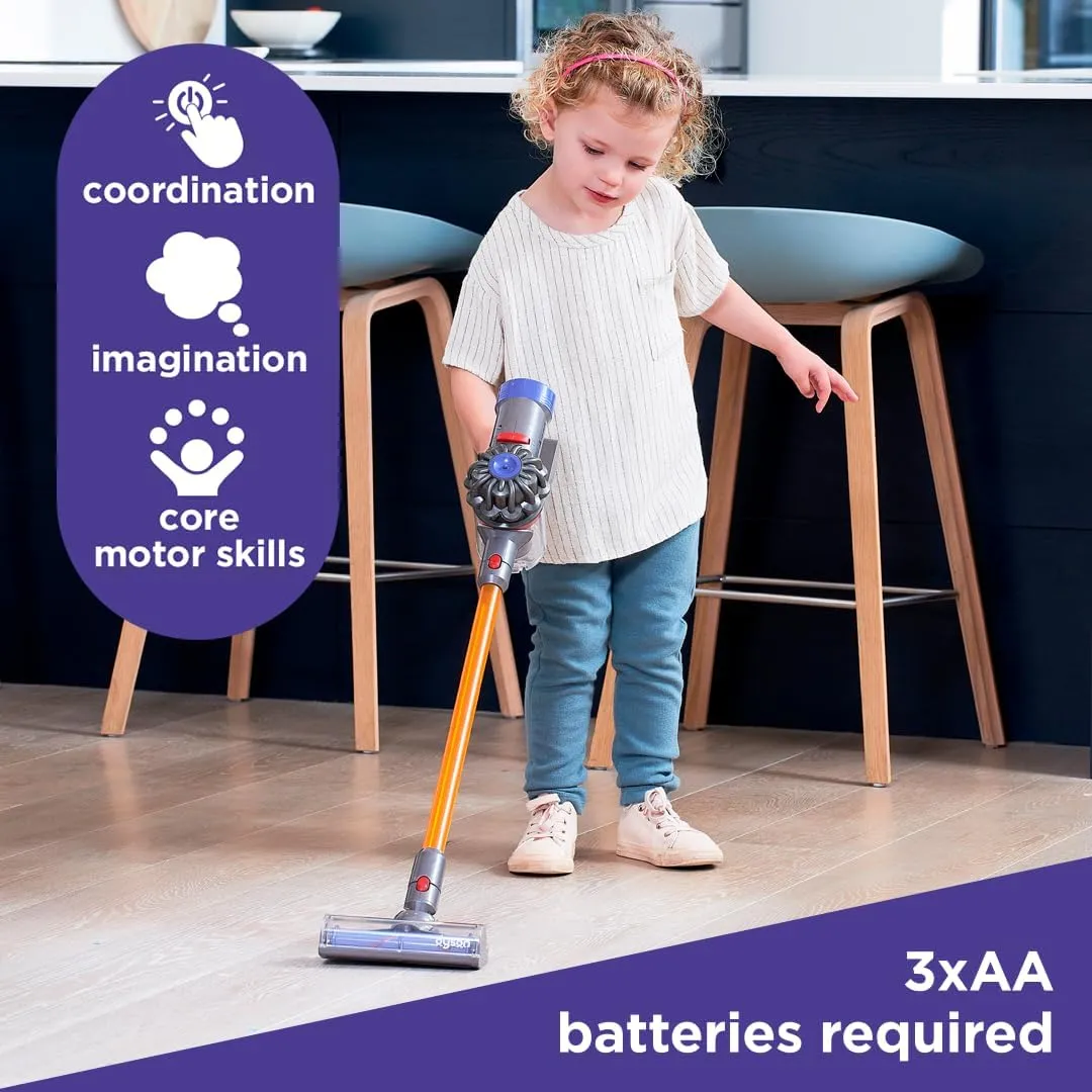 Toddler pushing a toy Dyson stick vacuum across a kitchen floor, in a product photo captioned âcoordination, imagination, core motor skillsâ
