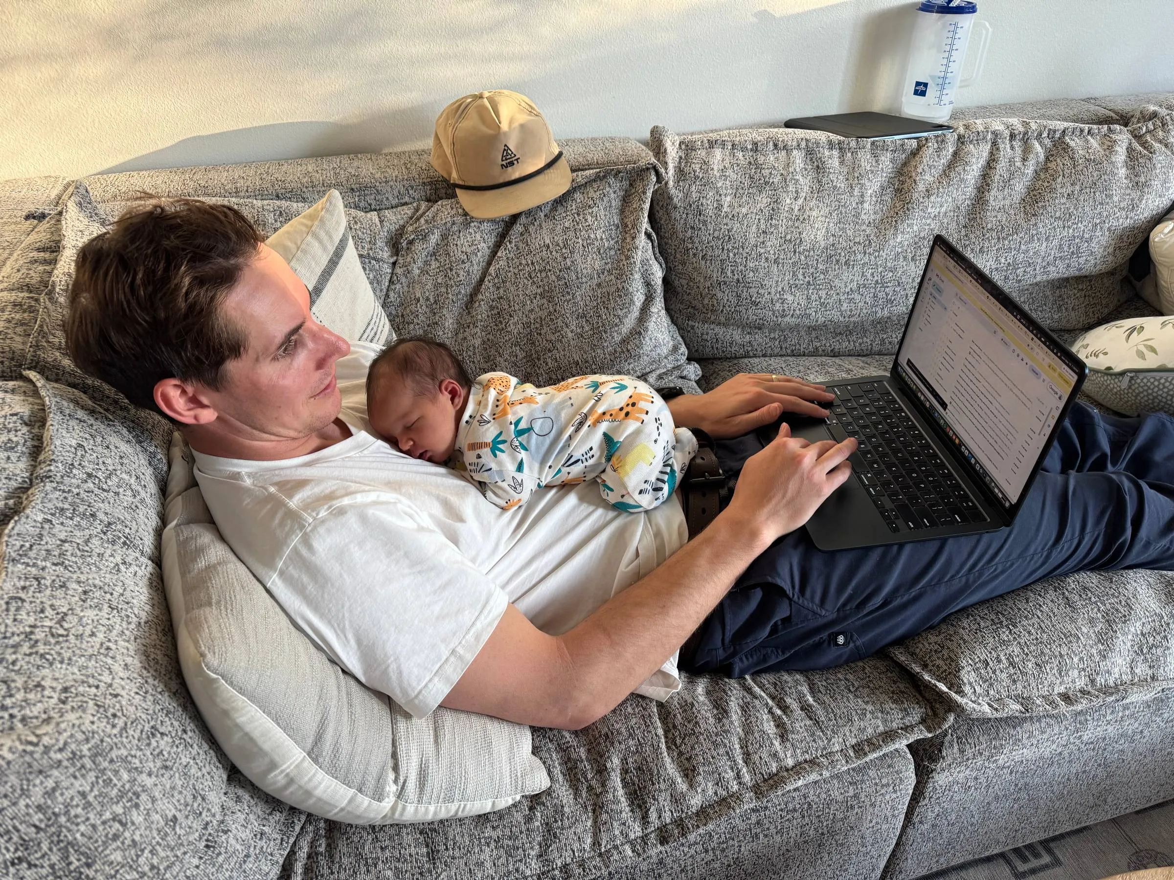 A newborn baby sleeping, the author’s new work-from-home office setup