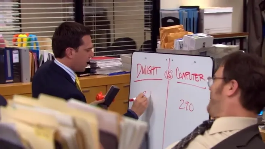 Scene from The Office showing a whiteboard tallying a “Dwight vs Computer” contest with a score of 290