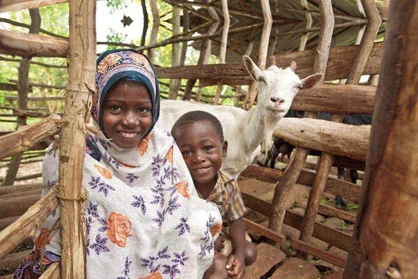A young girl standing with a goat