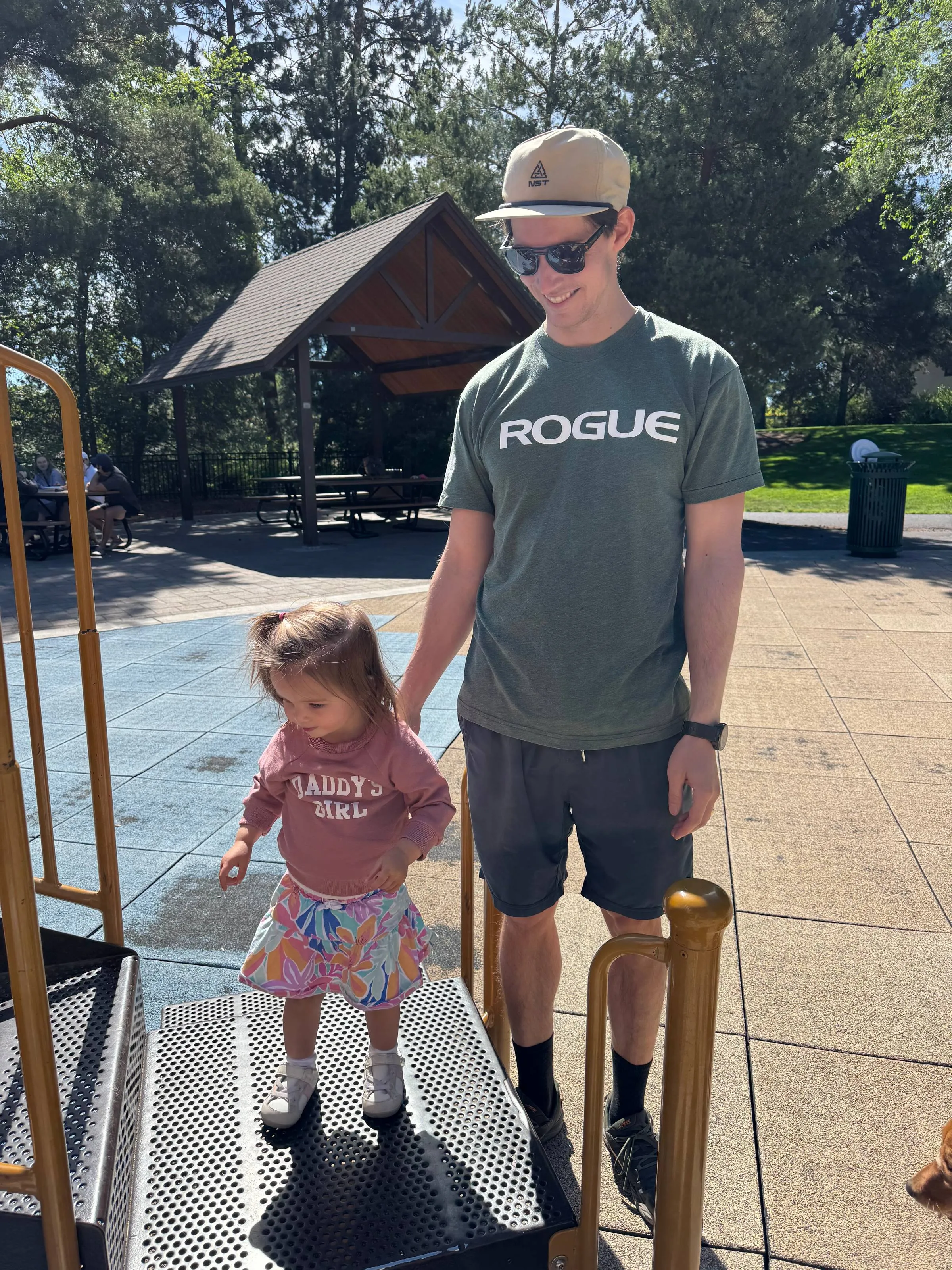 The author holding his toddler daughter’s hand at a park