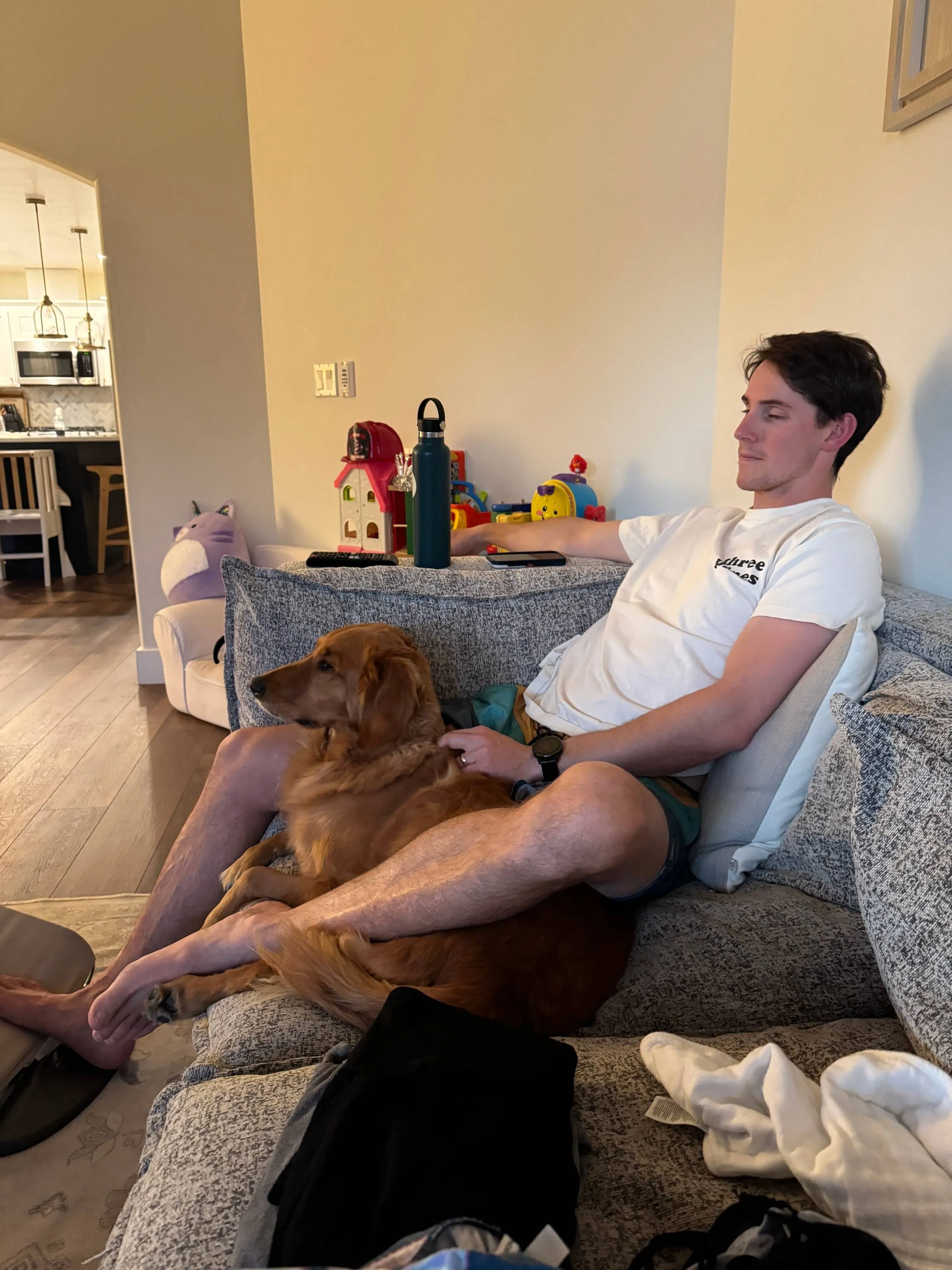 The author relaxing on the couch with his golden retriever resting across his lap