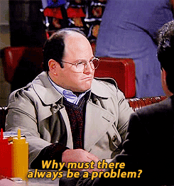 George Costanza from Seinfeld sitting in a diner booth with the caption âWhy must there always be a problem?â