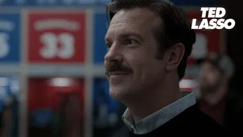 Animated Ted Lasso reaction clip of coach Ted smiling warmly with the âTED LASSOâ logo in the corner