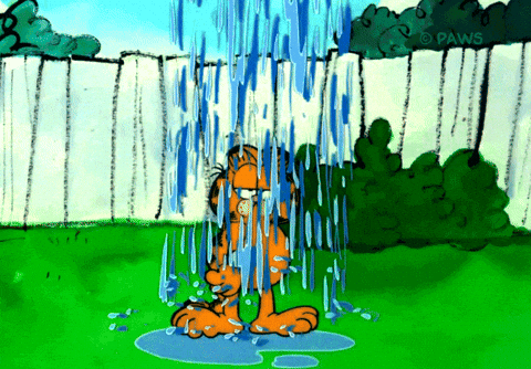 Cartoon cat Garfield sitting glumly in a backyard as rain pours down on him like a personal storm cloud