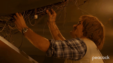 Animated GIF of a man in a plaid shirt looking overwhelmed while untangling a chaotic mess of wires